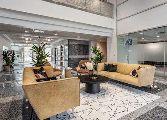 A contemporary living space at Altura Apartments furnished with a vibrant yellow sofa and a low coffee table.