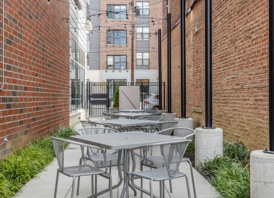 Four tables each surrounded by four chairs on an outdoor patio in Cincinnati, OH.
