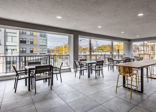 An outdoor sky lounge with tables, chairs, and a couch at Madamore.