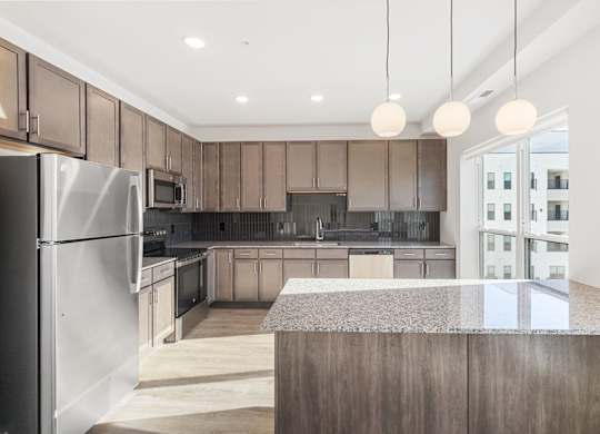 Altura Apartments, modern kitchen features a large central island with a countertop, suitable for dining or food preparation.
