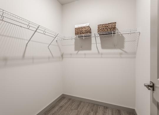 A bright white room fitted with a wire shelving unit holding two storage baskets.