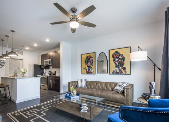 A furnished living room with a rig, next to a kitchen on hardwood-style floors in Cincinnati, OH.