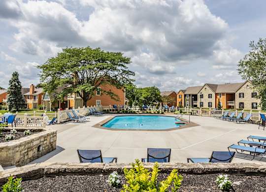 Fairway Lakes swimming pool surrounded by trees and lounge chairs,