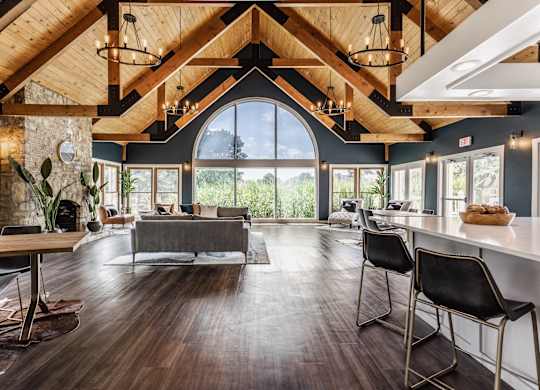 Community clubhouse with seating areas, hardwood-style flooring, and modern decor.