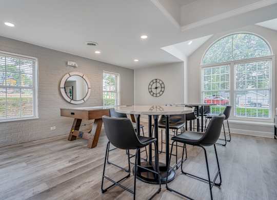 A dining room with a round table and chairs.