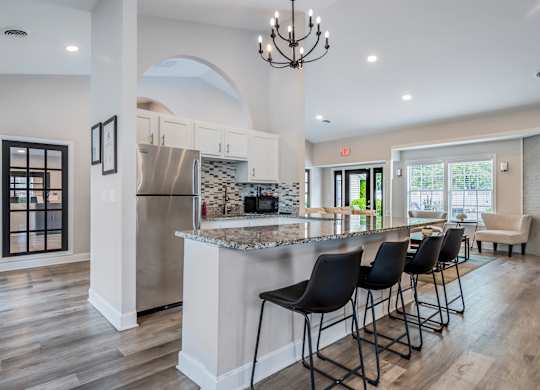 A kitchen with a bar and chairs.