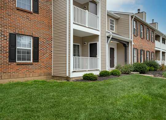 A row of townhouses with a green lawn in front.