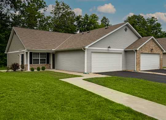 A house with a grey roof and two garages.