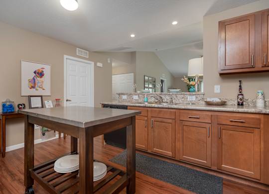 A kitchen with wooden cabinets and a white island.