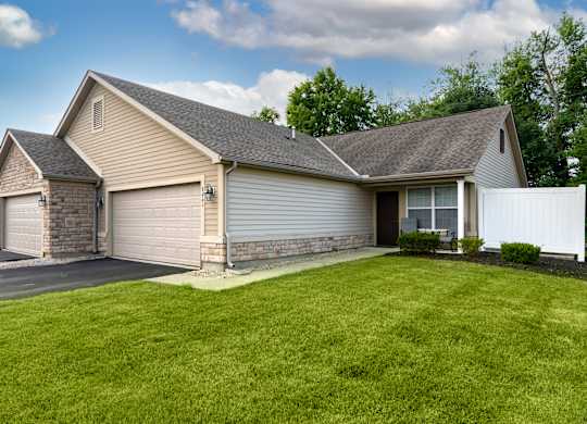 A house with a grey roof and a white fence.