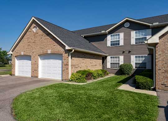 A house with a grey roof and a white garage door.