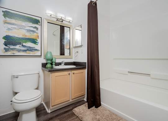 A bathroom with a toilet, sink, and bathtub.