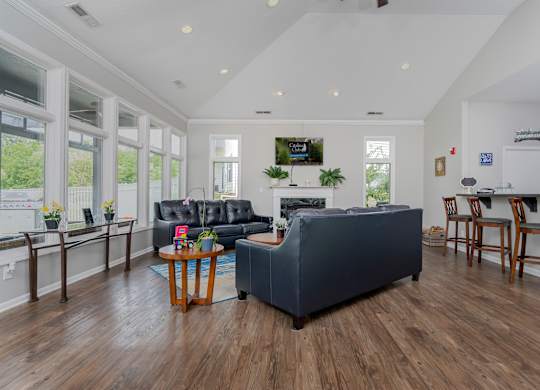 A living room with a grey couch and wooden floors.