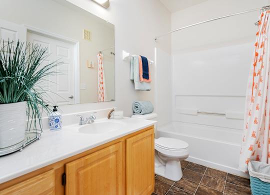 A bathroom with a toilet, sink, and shower.