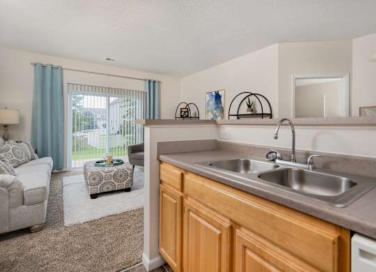 A kitchen with a sink and a window with curtains.