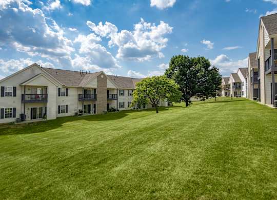 A row of houses with a green lawn in front.