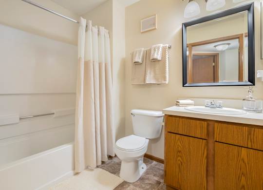 A white toilet sits in a bathroom next to a white sink.
