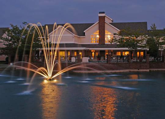 Exterior view of Britton Woods Apartments with pet-friendly walking paths and a pond with a fountain