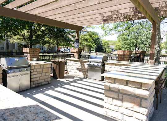 Outdoor patio area with BBQ grills and a shaded awning for community gatherings