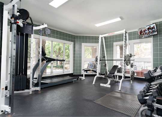 Fitness center at Britton Woods with free weights, cardio equipment, and a large window
