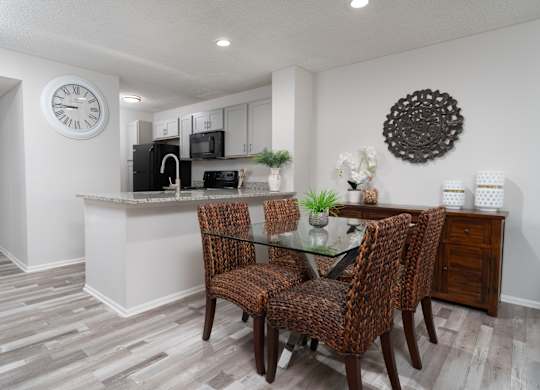 Renovated dining area at Britton Woods featuring granite counters, wood-style floors, and stainless steel appliances