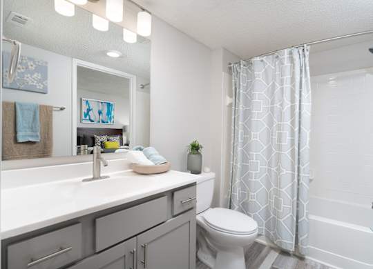 Modern bathroom with a shower, sink, and toilet in a renovated apartment