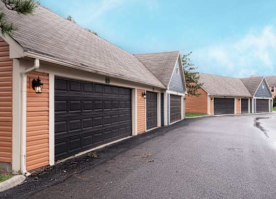 Exterior view of Fairway Lakes featuring black garage doors and a paved driveway.