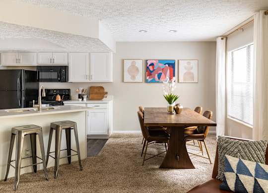 Fairway Lakes dining room featuring a dining room table, carpeted flooring, and modern decor, situated next to a kitchen.