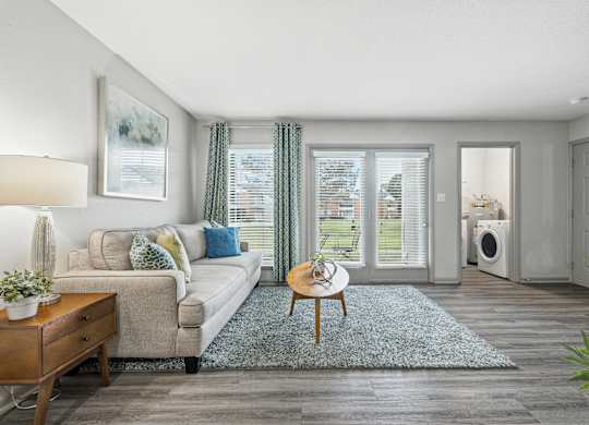 A living room with a couch, a coffee table, and a plant.