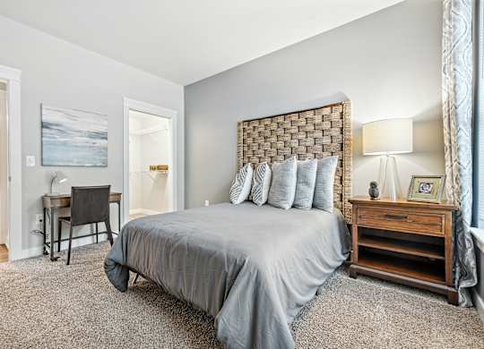 A bedroom with a large bed and a desk.
