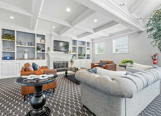 A living room with a grey couch and a black and white checkered floor.