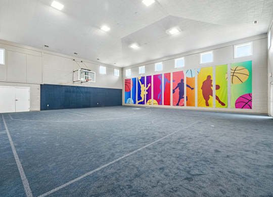 A basketball court with a wall of colorful basketball posters.