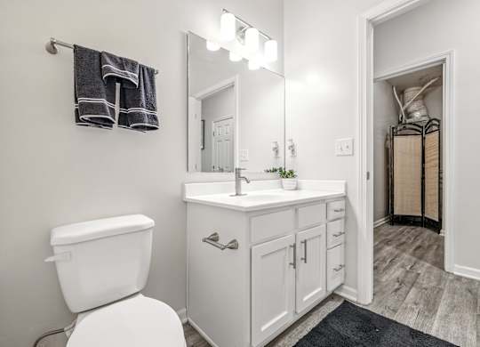 A white toilet sits next to a white sink in a bathroom.