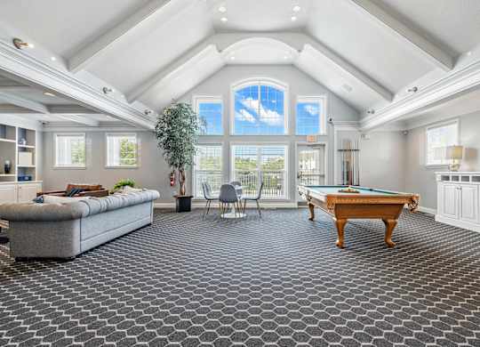 A room with a pool table and a couch.