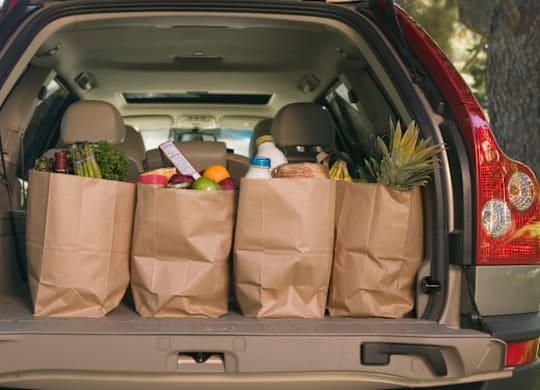 A car trunk is filled with groceries.
