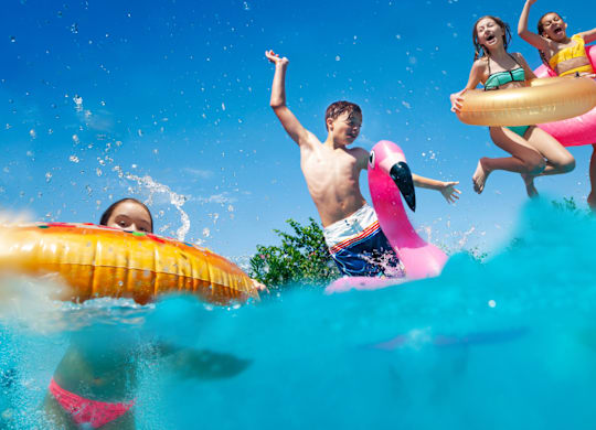 A group of people are enjoying a day in the water with inflatable rings.
