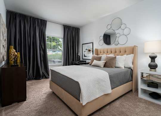 Cozy bedroom setup with bed, nightstand, and neutral tones at The Coleman Apartments