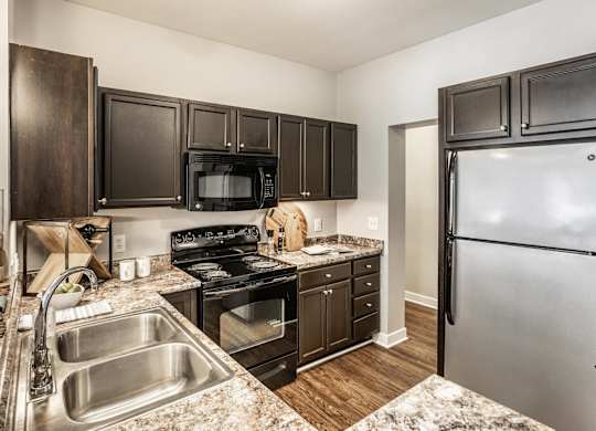 A kitchen with a sink, stove, and refrigerator.