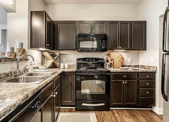A kitchen with black cabinets and appliances.