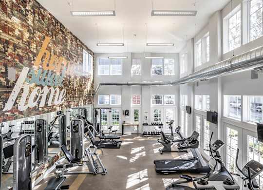 A gym with a brick wall and a variety of exercise equipment.