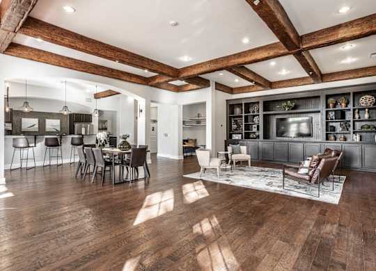 A spacious living room with wooden floors and a high ceiling.