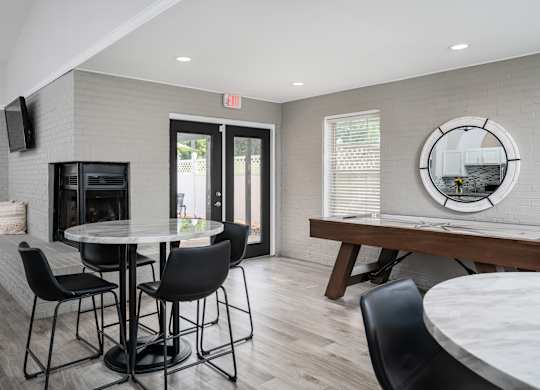 A clubhouse with a table surrounded by four chairs, and a door leading to outside.