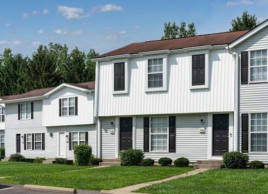 Exterior view of The Oaks with white panels and black shutters.