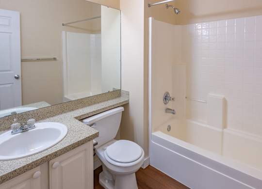 A white toilet sits next to a sink in a bathroom.