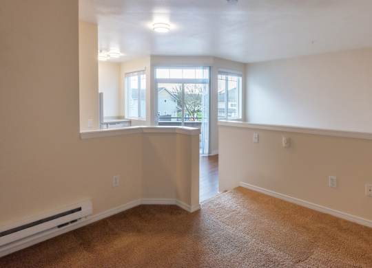 A room with a window and a door leading to another room.