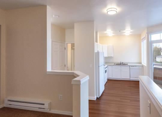 A kitchen with white cabinets and a window overlooking a street.