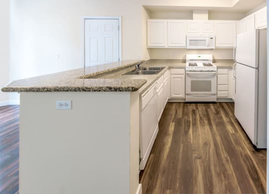 a kitchen with white appliances and a granite counter top