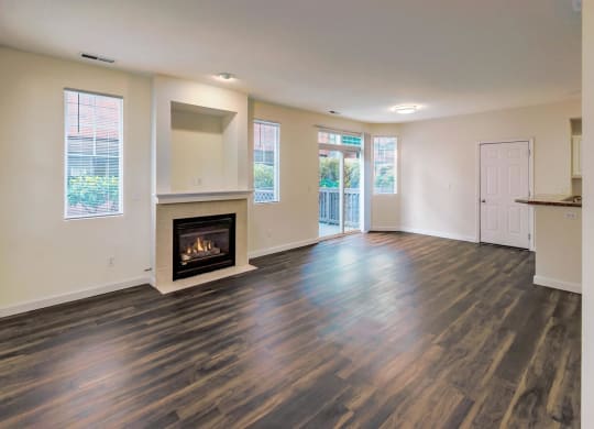 a living room with a fireplace and wooden floors