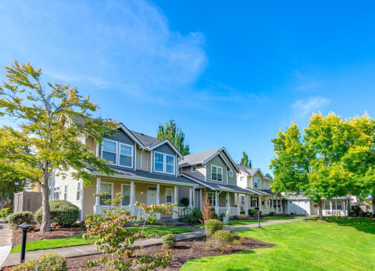 a row of houses with lawns and trees