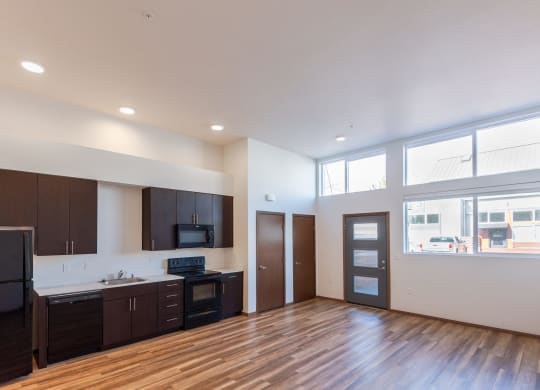 the view of a living room and kitchen in an empty apartment
